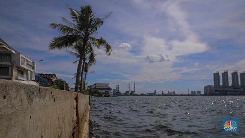Pengendara sepeda motor melintas di samping tanggul Pantai Mutiara, Penjaringan, Jakarta Utara, Senin (24/11/2025). (CNBC Indonesia/Faisal Rahman)