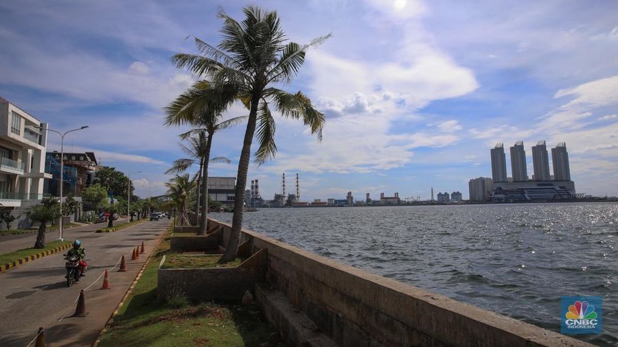 Pengendara sepeda motor melintas di samping tanggul Pantai Mutiara, Penjaringan, Jakarta Utara, Senin (24/11/2025). (CNBC Indonesia/Faisal Rahman)