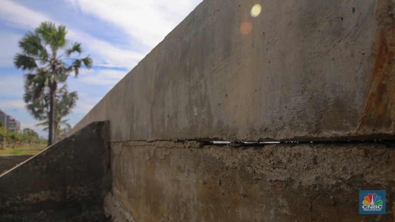 Pengendara sepeda motor melintas di samping tanggul Pantai Mutiara, Penjaringan, Jakarta Utara, Senin (24/11/2025). (CNBC Indonesia/Faisal Rahman)