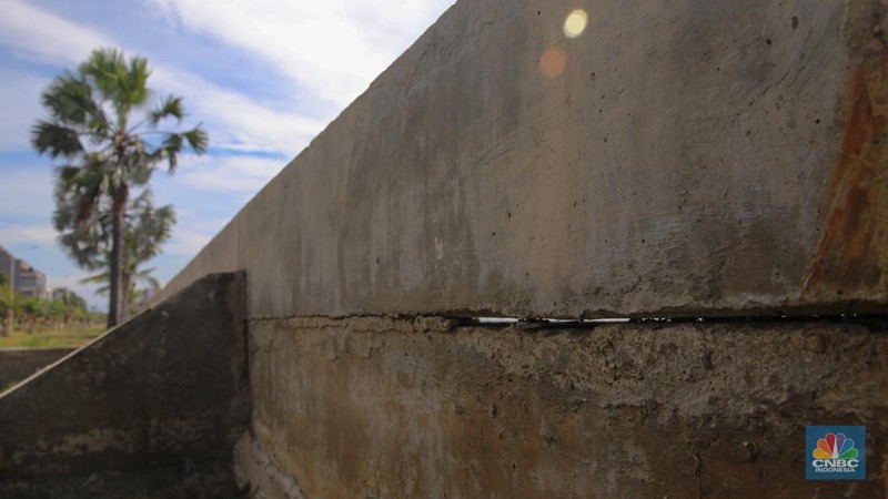 Pengendara sepeda motor melintas di samping tanggul Pantai Mutiara, Penjaringan, Jakarta Utara, Senin (24/11/2025). (CNBC Indonesia/Faisal Rahman)
