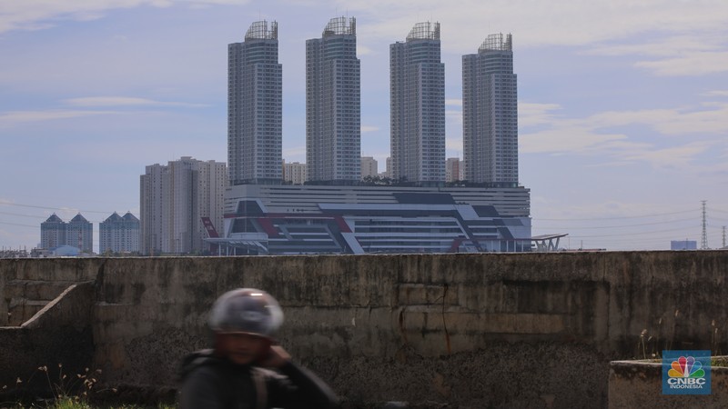 Pengendara sepeda motor melintas di samping tanggul Pantai Mutiara, Penjaringan, Jakarta Utara, Senin (24/11/2025). (CNBC Indonesia/Faisal Rahman)