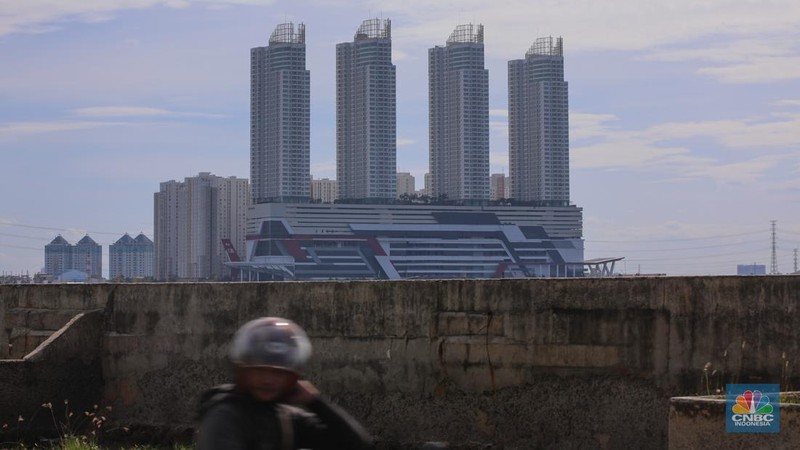 Pengendara sepeda motor melintas di samping tanggul Pantai Mutiara, Penjaringan, Jakarta Utara, Senin (24/11/2025). (CNBC Indonesia/Faisal Rahman)