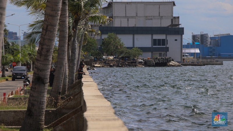 Pengendara sepeda motor melintas di samping tanggul Pantai Mutiara, Penjaringan, Jakarta Utara, Senin (24/11/2025). (CNBC Indonesia/Faisal Rahman)