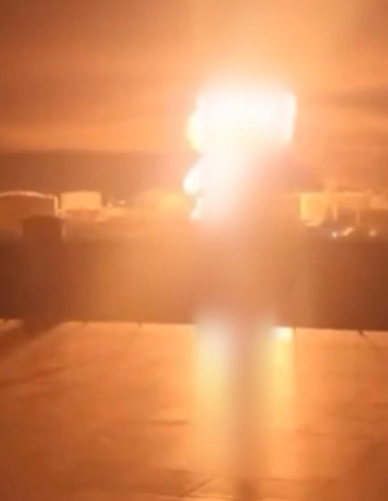 A person stands by an emergency vehicle as fire and smoke rise around the Shatura Power Station in Shatura, Russia, after Ukrainian drones struck the facility early Sunday, Moscow region governor Andrei Vorobyov said, in this still image taken from a social media video released November November 23, 2025. SOCIAL MEDIA/via REUTERS  THIS IMAGE HAS BEEN SUPPLIED BY A THIRD PARTY. NO RESALES. NO ARCHIVES. VERIFICATION LINES: - Reuters was able to confirm the location as buildings, signages and roadmap layout match with file images and satellite imagery. Date could not be independently verified. However, the governor of Moscow Region said on Telegram that Shatura Thermal Plant was attacked and caused fire this morning (November 23, 2025).