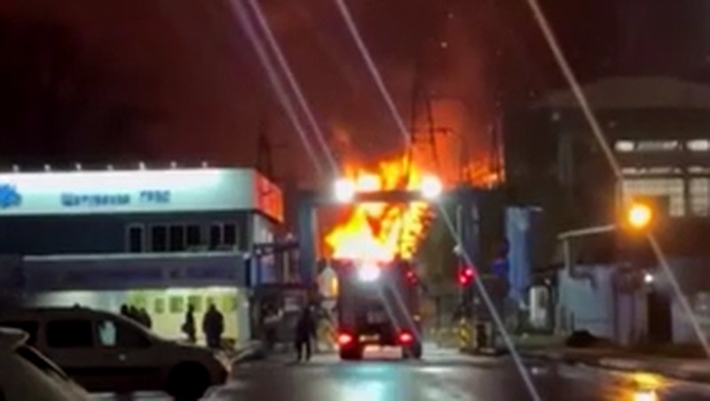 A person stands by an emergency vehicle as fire and smoke rise around the Shatura Power Station in Shatura, Russia, after Ukrainian drones struck the facility early Sunday, Moscow region governor Andrei Vorobyov said, in this still image taken from a social media video released November November 23, 2025. SOCIAL MEDIA/via REUTERS  THIS IMAGE HAS BEEN SUPPLIED BY A THIRD PARTY. NO RESALES. NO ARCHIVES. VERIFICATION LINES: - Reuters was able to confirm the location as buildings, signages and roadmap layout match with file images and satellite imagery. Date could not be independently verified. However, the governor of Moscow Region said on Telegram that Shatura Thermal Plant was attacked and caused fire this morning (November 23, 2025).