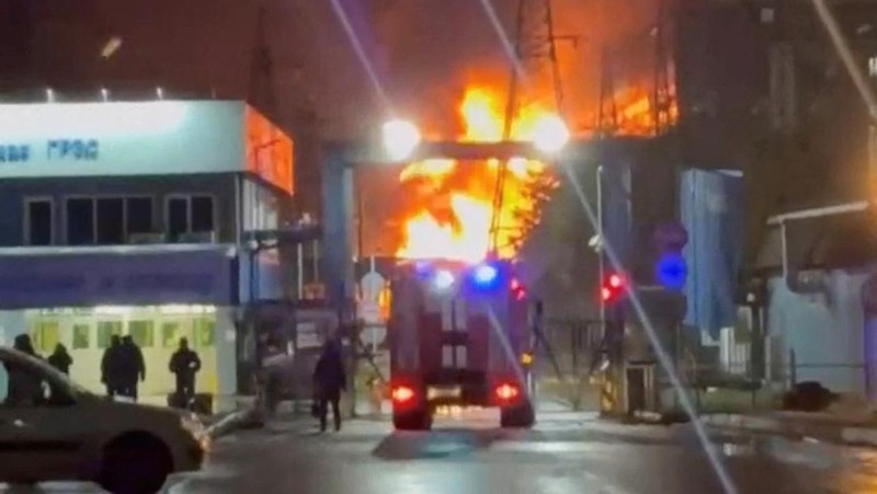 A person stands by an emergency vehicle as fire and smoke rise around the Shatura Power Station in Shatura, Russia, after Ukrainian drones struck the facility early Sunday, Moscow region governor Andrei Vorobyov said, in this still image taken from a social media video released November November 23, 2025. SOCIAL MEDIA/via REUTERS  THIS IMAGE HAS BEEN SUPPLIED BY A THIRD PARTY. NO RESALES. NO ARCHIVES. VERIFICATION LINES: - Reuters was able to confirm the location as buildings, signages and roadmap layout match with file images and satellite imagery. Date could not be independently verified. However, the governor of Moscow Region said on Telegram that Shatura Thermal Plant was attacked and caused fire this morning (November 23, 2025).