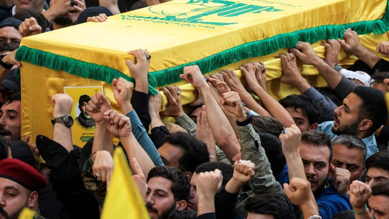 Anggota Hizbullah membawa peti mati orang-orang yang tewas dalam serangan Israel, di distrik Nabatieh, Lebanon selatan, 2 November 2025. (REUTERS/Ali Hankir)