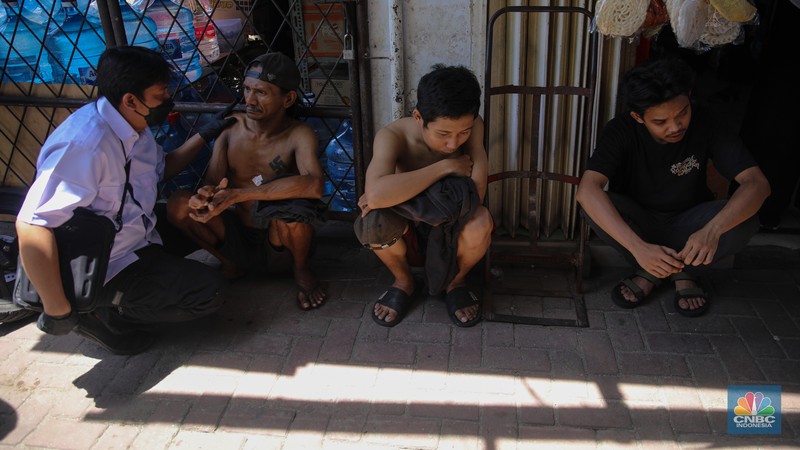 Petugas mengamankan terduga pelaku peredaean narkotika saat melakukan penggerebekan di kawasan Berland, Jalan Kesatrian, Matraman, Jakarta, Selasa (25/11/2025). (CNBC Indonesia/Faisal Rahman)