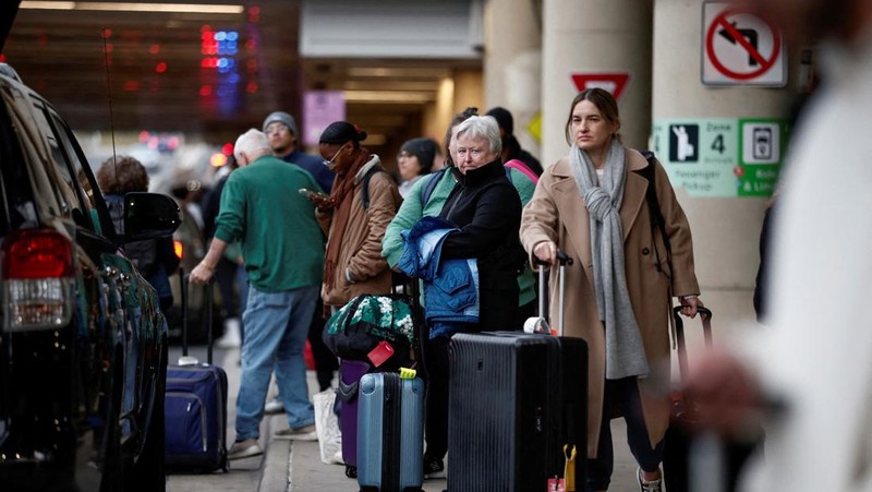 Penumpang berjalan melewati terminal pada hari perjalanan tersibuk di libur Thanksgiving, di Bandara Nasional Ronald Reagan Washington di Arlington, Virginia, AS, 25 November 2025. (REUTERS/Kevin Lamarque)