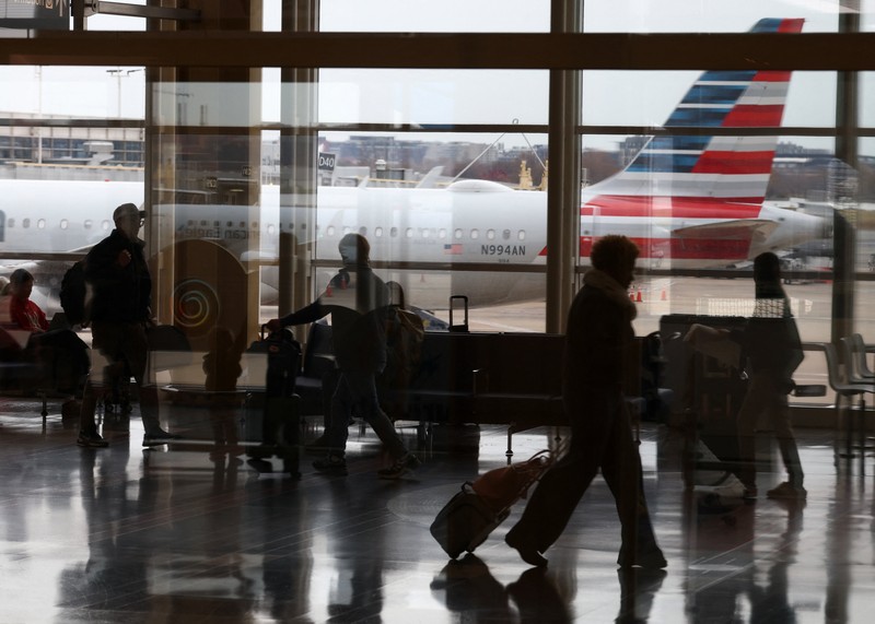 Penumpang berjalan melewati terminal pada hari perjalanan tersibuk di libur Thanksgiving, di Bandara Nasional Ronald Reagan Washington di Arlington, Virginia, AS, 25 November 2025. (REUTERS/Kevin Lamarque)