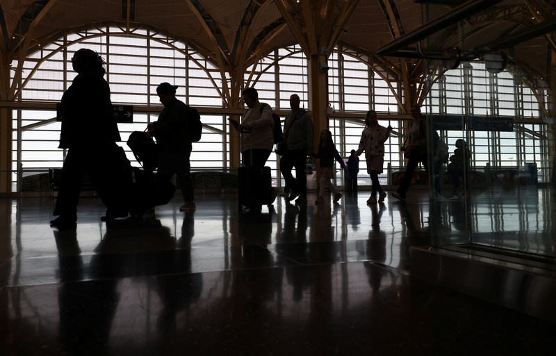 Penumpang berjalan melewati terminal pada hari perjalanan tersibuk di libur Thanksgiving, di Bandara Nasional Ronald Reagan Washington di Arlington, Virginia, AS, 25 November 2025. (REUTERS/Kevin Lamarque)