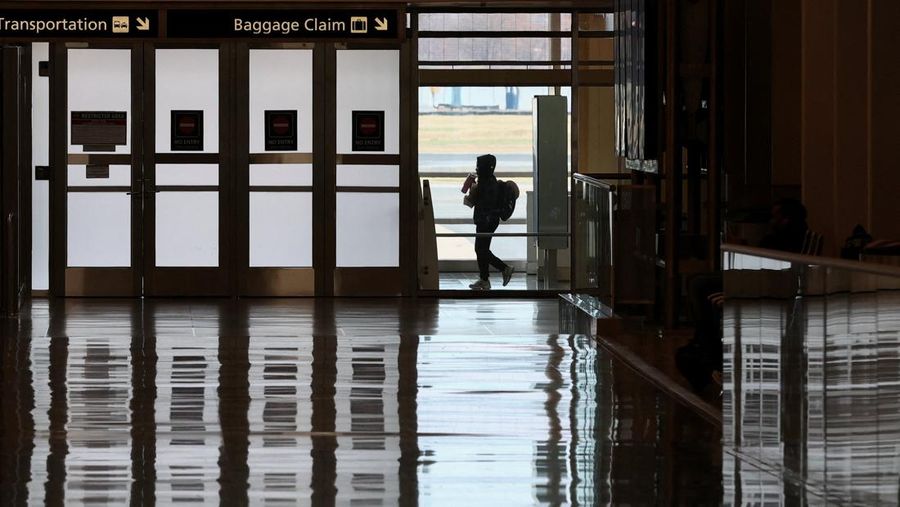 Penumpang berjalan melewati terminal pada hari perjalanan tersibuk di libur Thanksgiving, di Bandara Nasional Ronald Reagan Washington di Arlington, Virginia, AS, 25 November 2025. (REUTERS/Kevin Lamarque)