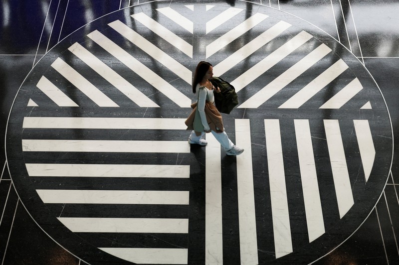 Penumpang berjalan melewati terminal pada hari perjalanan tersibuk di libur Thanksgiving, di Bandara Nasional Ronald Reagan Washington di Arlington, Virginia, AS, 25 November 2025. (REUTERS/Kevin Lamarque)
