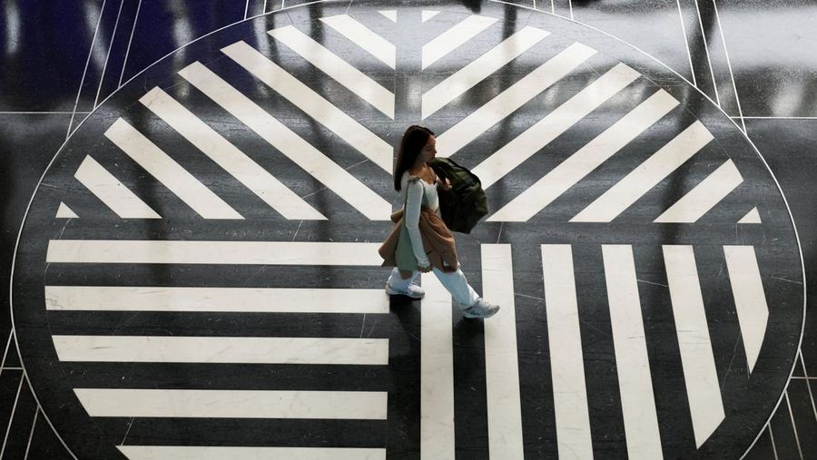 Penumpang berjalan melewati terminal pada hari perjalanan tersibuk di libur Thanksgiving, di Bandara Nasional Ronald Reagan Washington di Arlington, Virginia, AS, 25 November 2025. (REUTERS/Kevin Lamarque)