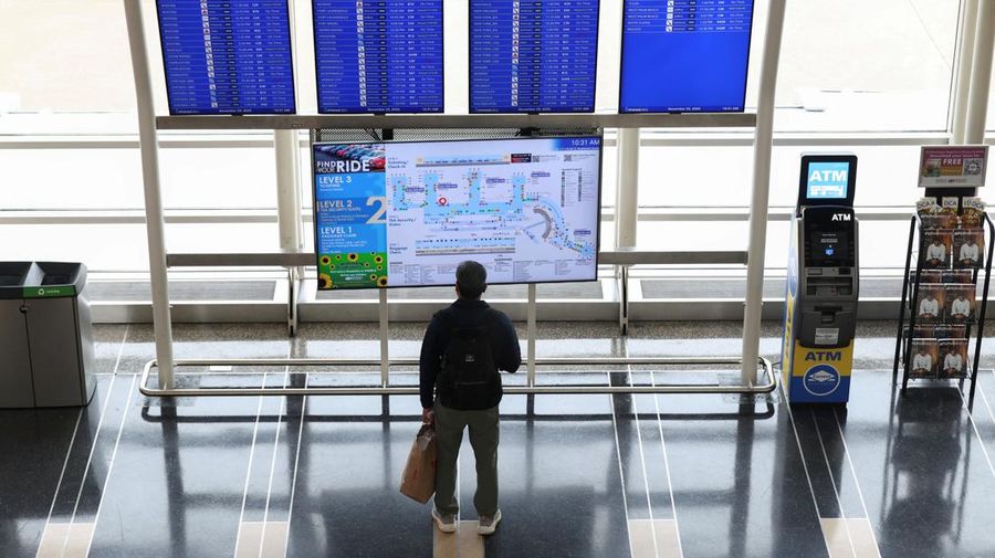 Penumpang berjalan melewati terminal pada hari perjalanan tersibuk di libur Thanksgiving, di Bandara Nasional Ronald Reagan Washington di Arlington, Virginia, AS, 25 November 2025. (REUTERS/Kevin Lamarque)