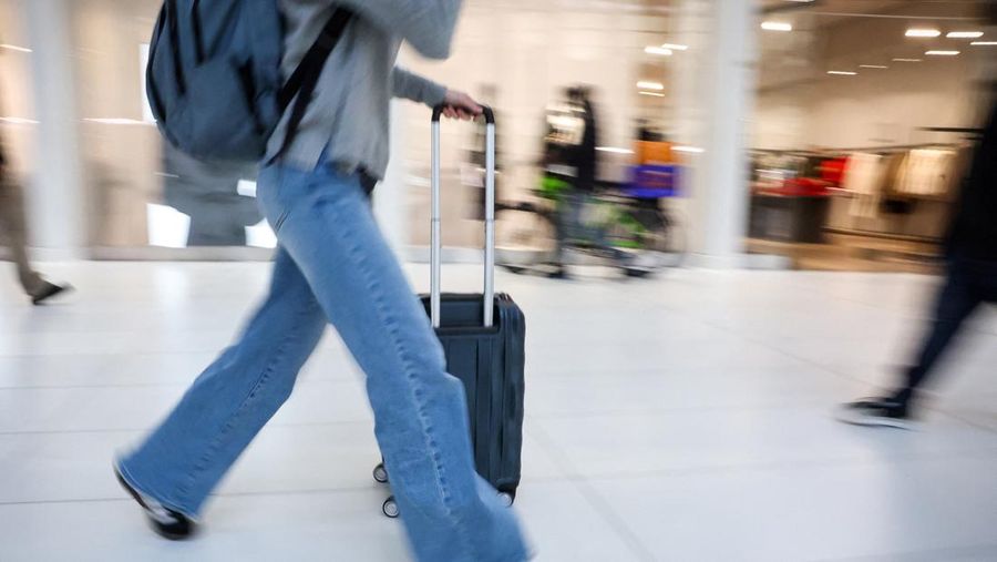 Penumpang berjalan melewati terminal pada hari perjalanan tersibuk di libur Thanksgiving, di Bandara Nasional Ronald Reagan Washington di Arlington, Virginia, AS, 25 November 2025. (REUTERS/Kevin Lamarque)
