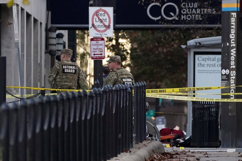 Anggota Garda Nasional berdiri di area yang ditutup dengan penanda bukti yang ditempatkan di tanah, setelah dua anggota Garda Nasional ditembak di dekat Gedung Putih di Washington, D.C., AS, 26 November 2025. (REUTERS/Nathan Howard)