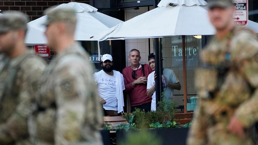 Anggota Garda Nasional berdiri di area yang ditutup dengan penanda bukti yang ditempatkan di tanah, setelah dua anggota Garda Nasional ditembak di dekat Gedung Putih di Washington, D.C., AS, 26 November 2025. (REUTERS/Nathan Howard)
