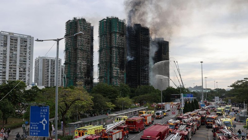 Polisi berjaga di lokasi kebakaran besar di perumahan Wang Fuk Court, di mana api melalap perancah bambu di beberapa blok, menewaskan sedikitnya 44 orang dan menyebabkan hampir 300 orang hilang, di Tai Po, Hong Kong, Tiongkok, 27 November 2025. (REUTERS/Tyrone Siu)