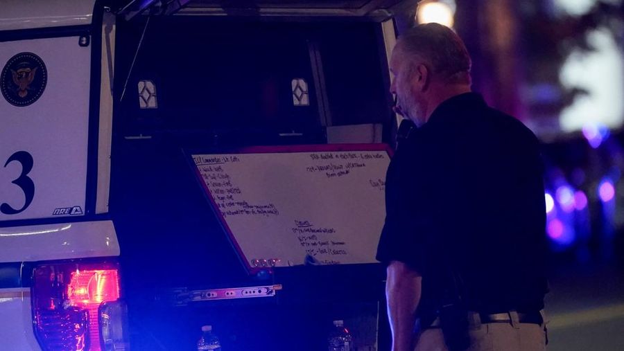 Seorang anggota Dinas Rahasia AS berdiri di samping papan tulis yang dipasang di kendaraan, setelah dua anggota Garda Nasional ditembak di dekat Gedung Putih, di Washington, D.C., AS, 26 November 2025. (REUTERS/Nathan Howard)