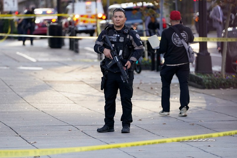 Anggota Garda Nasional berdiri di area yang ditutup dengan penanda bukti yang ditempatkan di tanah, setelah dua anggota Garda Nasional ditembak di dekat Gedung Putih di Washington, D.C., AS, 26 November 2025. (REUTERS/Nathan Howard)