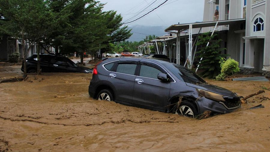 Mobil-mobil yang terendam sebagian terjebak di kawasan pemukiman yang terdampak banjir, menyusul hujan lebat di Padang, provinsi Sumatera Barat, Indonesia, 27 November 2025. (REUTERS/Stringer)