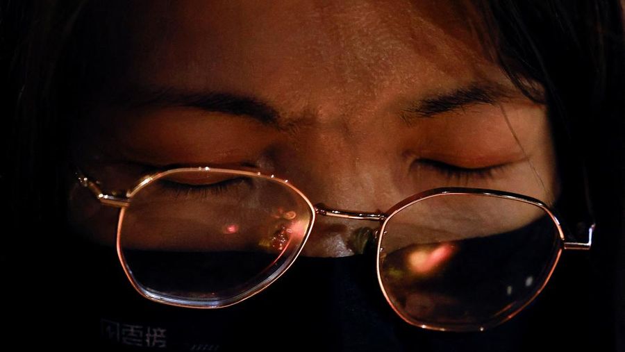 Orang-orang memegang kertas doa saat berkumpul, setelah kebakaran mematikan di kompleks perumahan Wang Fuk Court di Tai Po, Hong Kong, Cina, 28 November 2025. (REUTERS/Maxim Shemetov)