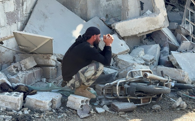 Seorang pria duduk di reruntuhan lokasi yang rusak setelah serangan Israel pada hari Jumat, menurut media pemerintah Suriah, di Beit Jinn, Suriah, 28 November 2025. (REUTERS/Ali Ahmed al-Najjar)
