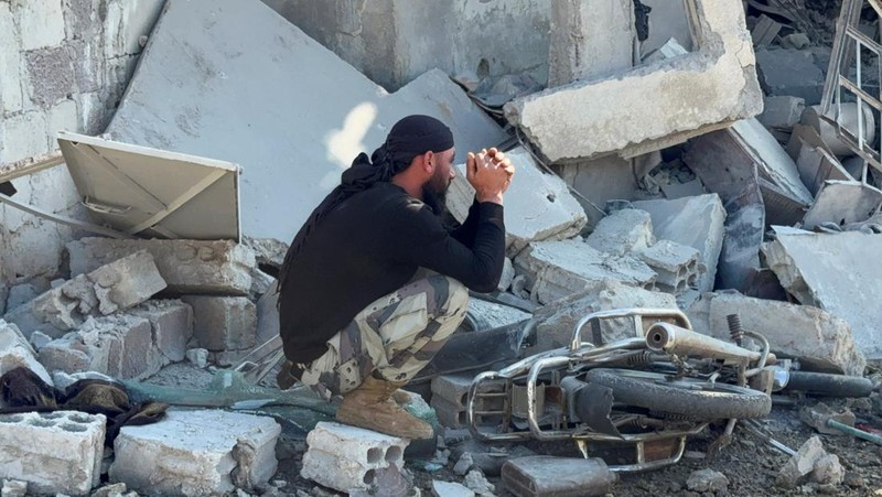 Seorang pria duduk di reruntuhan lokasi yang rusak setelah serangan Israel pada hari Jumat, menurut media pemerintah Suriah, di Beit Jinn, Suriah, 28 November 2025. (REUTERS/Ali Ahmed al-Najjar)