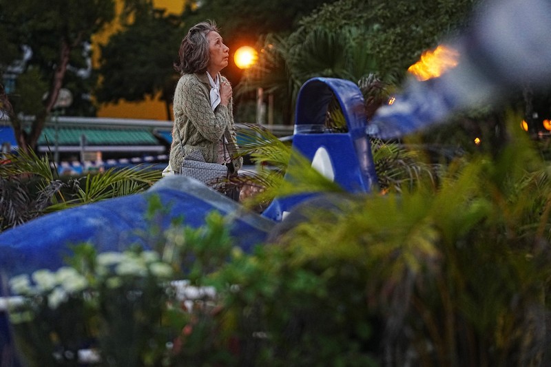 Orang-orang memegang kertas doa saat berkumpul, setelah kebakaran mematikan di kompleks perumahan Wang Fuk Court di Tai Po, Hong Kong, Cina, 28 November 2025. (REUTERS/Maxim Shemetov)