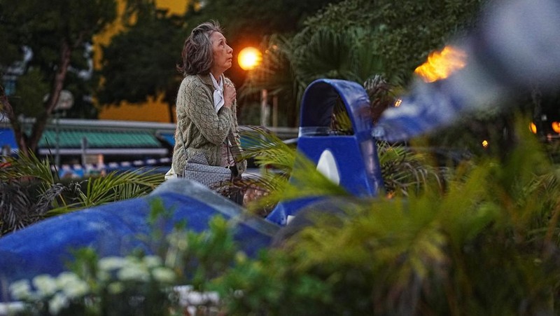Orang-orang memegang kertas doa saat berkumpul, setelah kebakaran mematikan di kompleks perumahan Wang Fuk Court di Tai Po, Hong Kong, Cina, 28 November 2025. (REUTERS/Maxim Shemetov)