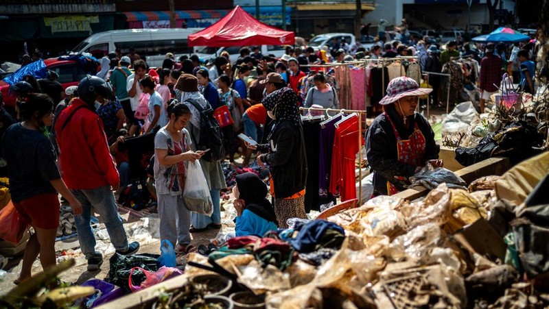 Orang-orang berbelanja produk yang rusak akibat banjir setelah banjir mematikan di distrik Hat Yai, provinsi Songkhla, Thailand, 30 November 2025. (REUTERS/Athit Perawongmetha)