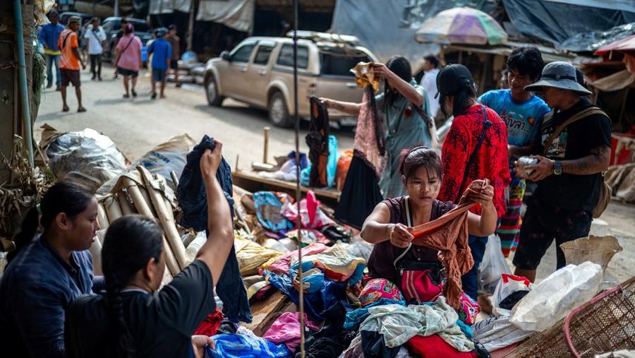 Orang-orang berbelanja produk yang rusak akibat banjir setelah banjir mematikan di distrik Hat Yai, provinsi Songkhla, Thailand, 30 November 2025. (REUTERS/Athit Perawongmetha)