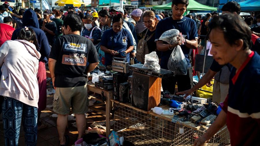 Orang-orang berbelanja produk yang rusak akibat banjir setelah banjir mematikan di distrik Hat Yai, provinsi Songkhla, Thailand, 30 November 2025. (REUTERS/Athit Perawongmetha)