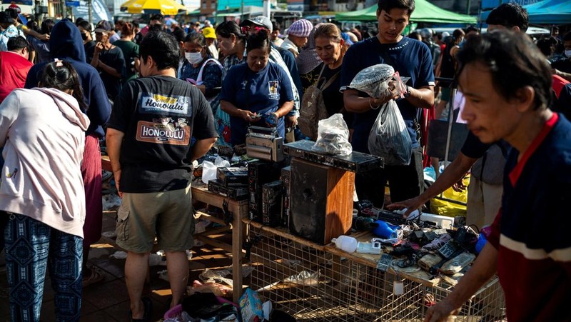 Orang-orang berbelanja produk yang rusak akibat banjir setelah banjir mematikan di distrik Hat Yai, provinsi Songkhla, Thailand, 30 November 2025. (REUTERS/Athit Perawongmetha)