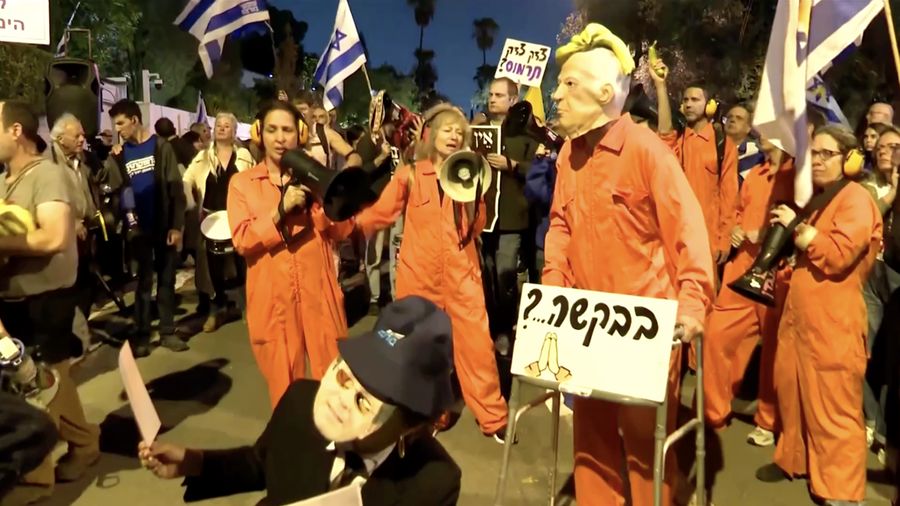 Para pengunjuk rasa berkumpul di luar kediaman pribadi Presiden Israel Isaac Herzog pada Minggu (30/11/2025). (Tangkapan Layar Video Reuters/)