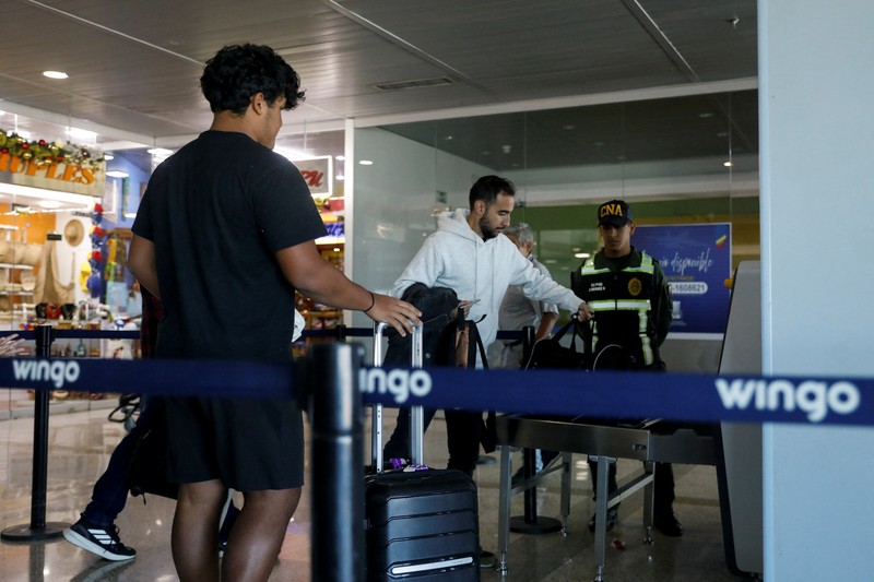 Penumpang mengantre untuk menaiki pesawat Wingo Airlines menuju Bogota, di Bandara Internasional Simon Bolivar, setelah Presiden AS Donald Trump mengatakan pada hari Sabtu bahwa wilayah udara di atas dan di sekitar Venezuela harus dianggap 