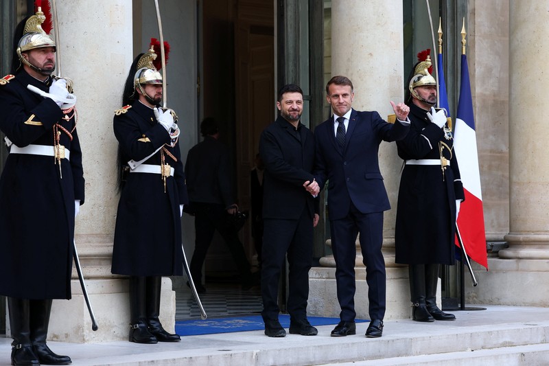 Presiden Prancis Emmanuel Macron menyambut Presiden Ukraina Volodymyr Zelenskiy saat ia tiba untuk pertemuan di Istana Elysee, Paris, Prancis, Senin (1/12/2025). (REUTERS/Sarah Meyssonnier)