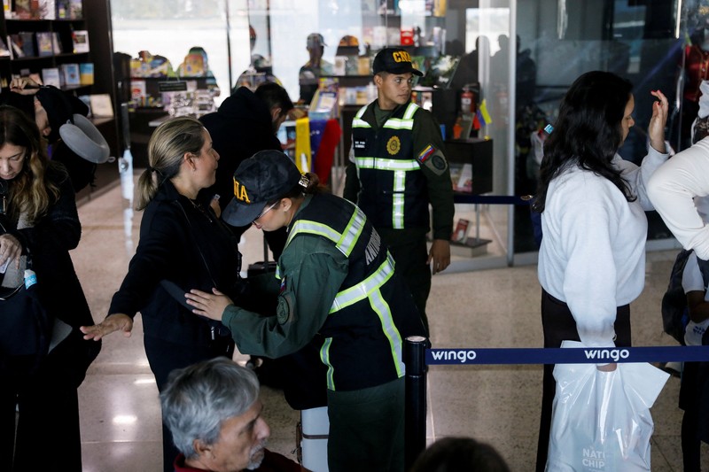 Penumpang mengantre untuk menaiki pesawat Wingo Airlines menuju Bogota, di Bandara Internasional Simon Bolivar, setelah Presiden AS Donald Trump mengatakan pada hari Sabtu bahwa wilayah udara di atas dan di sekitar Venezuela harus dianggap 