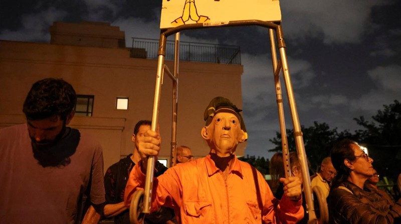 Para pengunjuk rasa berkumpul di luar kediaman pribadi Presiden Israel Isaac Herzog pada Minggu (30/11/2025). (Tangkapan Layar Video Reuters/)