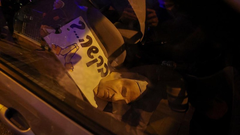 Para pengunjuk rasa berkumpul di luar kediaman pribadi Presiden Israel Isaac Herzog pada Minggu (30/11/2025). (Tangkapan Layar Video Reuters/)