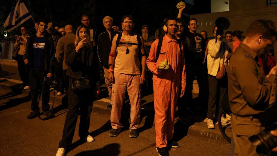 Para pengunjuk rasa berkumpul di luar kediaman pribadi Presiden Israel Isaac Herzog pada Minggu (30/11/2025). (Tangkapan Layar Video Reuters/)