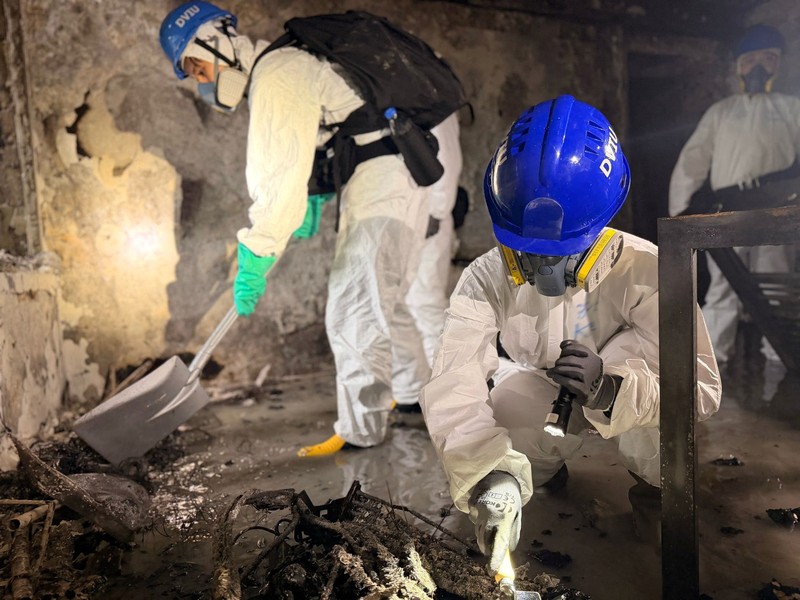 Petugas polisi membawa jenazah korban yang ditemukan dari blok perumahan yang rusak akibat kebakaran di kompleks perumahan Wang Fuk Court setelah kebakaran mematikan, di Tai Po, Hong Kong, Tiongkok, 1 Desember 2025. (REUTERS/Maxim Shemetov)