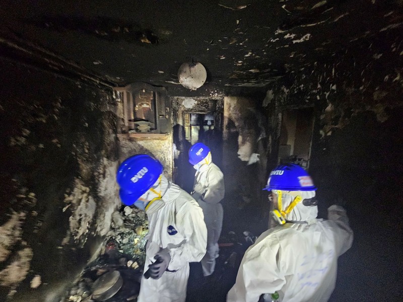 Petugas polisi membawa jenazah korban yang ditemukan dari blok perumahan yang rusak akibat kebakaran di kompleks perumahan Wang Fuk Court setelah kebakaran mematikan, di Tai Po, Hong Kong, Tiongkok, 1 Desember 2025. (REUTERS/Maxim Shemetov)