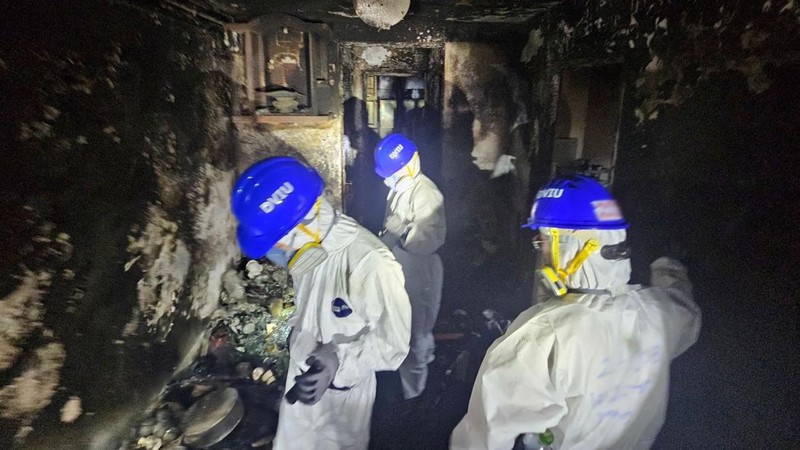 Petugas polisi membawa jenazah korban yang ditemukan dari blok perumahan yang rusak akibat kebakaran di kompleks perumahan Wang Fuk Court setelah kebakaran mematikan, di Tai Po, Hong Kong, Tiongkok, 1 Desember 2025. (REUTERS/Maxim Shemetov)