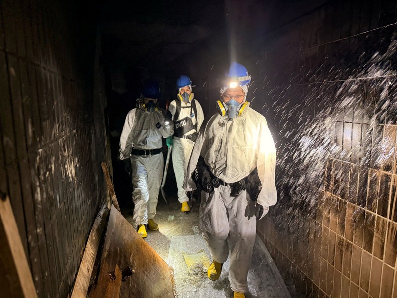 Petugas polisi membawa jenazah korban yang ditemukan dari blok perumahan yang rusak akibat kebakaran di kompleks perumahan Wang Fuk Court setelah kebakaran mematikan, di Tai Po, Hong Kong, Tiongkok, 1 Desember 2025. (REUTERS/Maxim Shemetov)