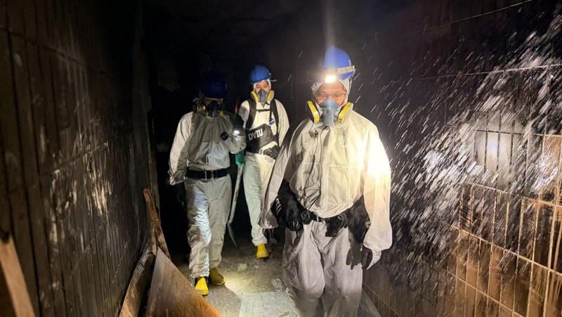 Petugas polisi membawa jenazah korban yang ditemukan dari blok perumahan yang rusak akibat kebakaran di kompleks perumahan Wang Fuk Court setelah kebakaran mematikan, di Tai Po, Hong Kong, Tiongkok, 1 Desember 2025. (REUTERS/Maxim Shemetov)