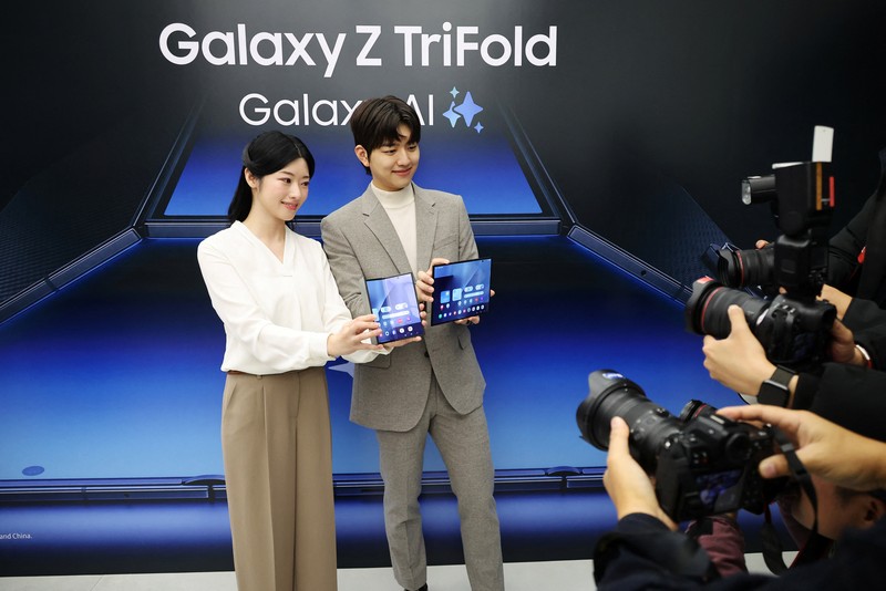 Seorang model berpose untuk foto dengan Galaxy Z TriFold selama acara di tokonya di Seoul, Korea Selatan, 2 Desember 2025. (REUTERS/Kim Hong-Ji)