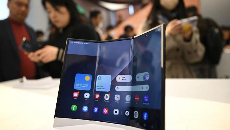 Seorang model berpose untuk foto dengan Galaxy Z TriFold selama acara di tokonya di Seoul, Korea Selatan, 2 Desember 2025. (REUTERS/Kim Hong-Ji)