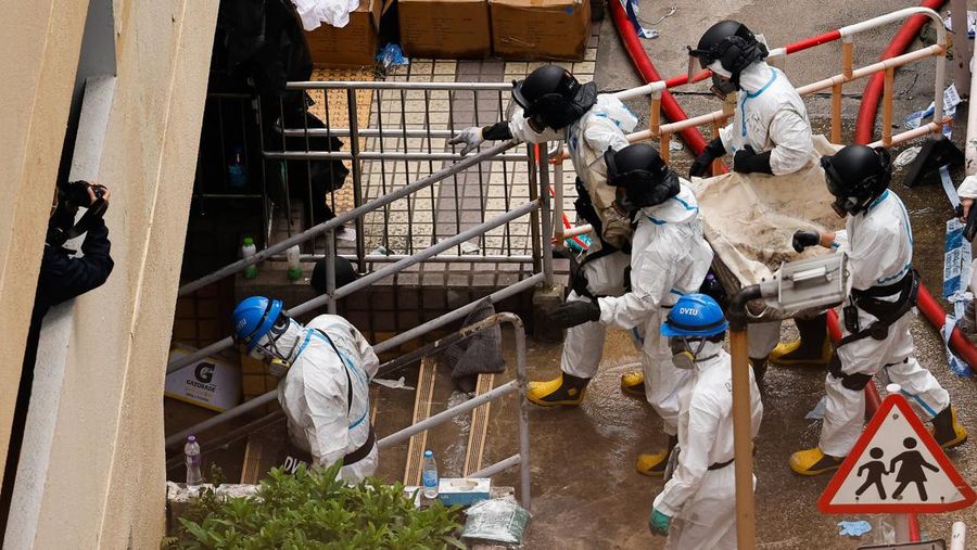 Petugas polisi membawa jenazah korban yang ditemukan dari blok perumahan yang rusak akibat kebakaran di kompleks perumahan Wang Fuk Court setelah kebakaran mematikan, di Tai Po, Hong Kong, Tiongkok, 1 Desember 2025. (REUTERS/Maxim Shemetov)